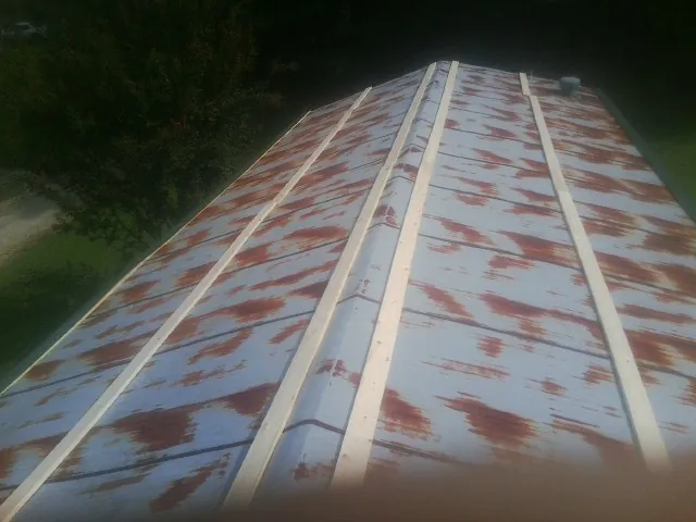 Rusted metal roof panels with new wood purlins before replacement — Storm Damage Roof Repair in Adairville by Roofing Brothers