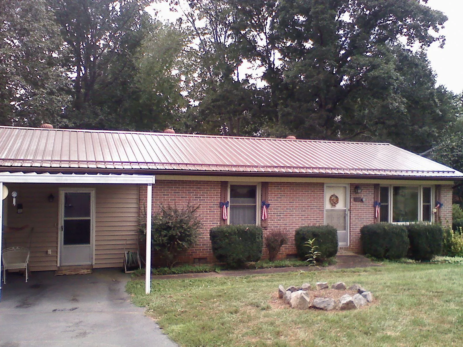 Bronze metal roof and carport on a brick ranch home — Roof Repair work by our crew in Adairville